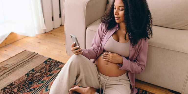 pregnant woman looking at her phone